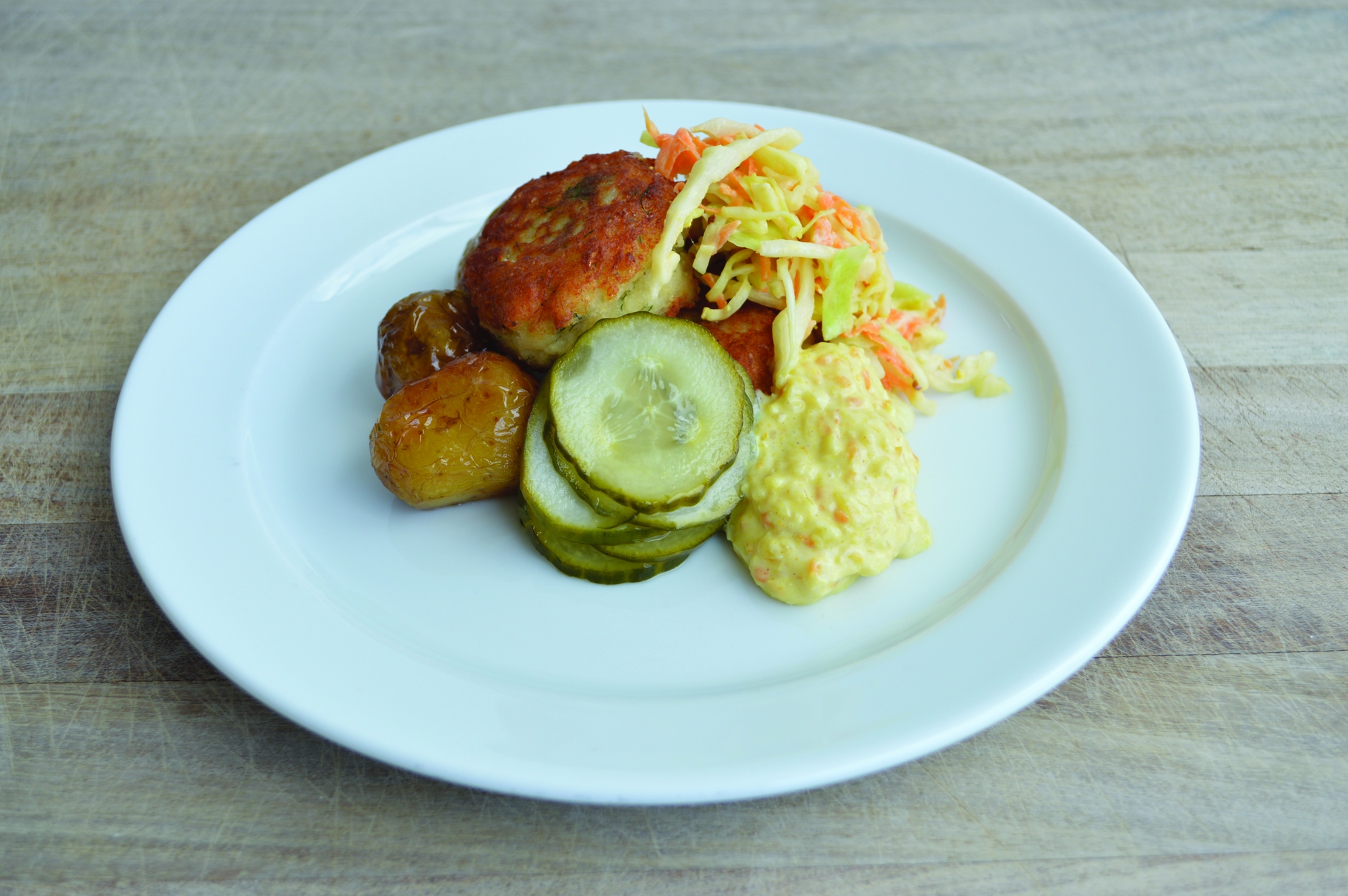 Fiskefrikadeller Med Stegte Kartofler, Coleslaw, Remoulade Og Syltede Agurker